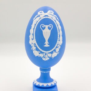 This is a white and blue hand-painted goose egg, depicting a ancient Greek vase