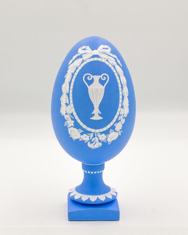 This is a white and blue hand-painted goose egg, depicting a ancient Greek vase