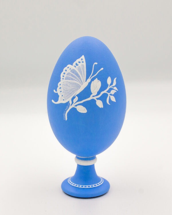This is a white and blue handpainted goose eggshell, depicting a blossomed flower