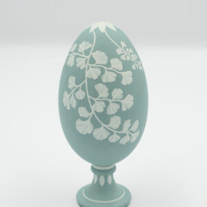 This is This is a white and green handpainted goose eggshella white and blue handpainted goose eggshell